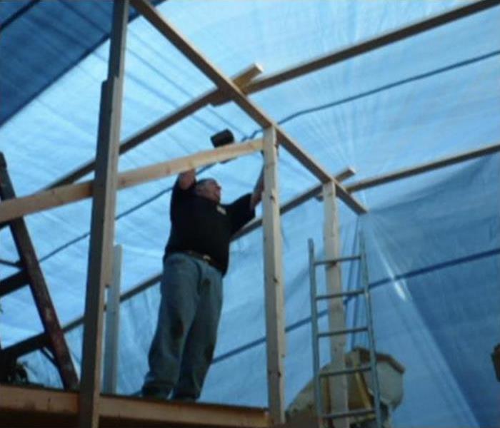 SERVPRO technician setting up tarp roofing