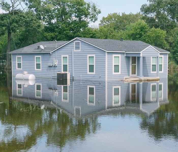 Blue house surrounded by floodwaters. 