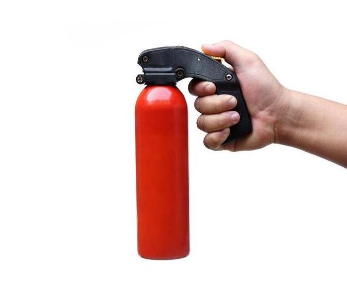 Hand holding a fire extinguisher