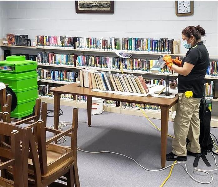 SERVPRO employee cleaning books